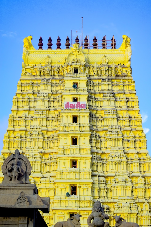 south india - south india Close-up view of a yellow South India temple's gopuram, showcasing intricate carvings and sculptures, south india