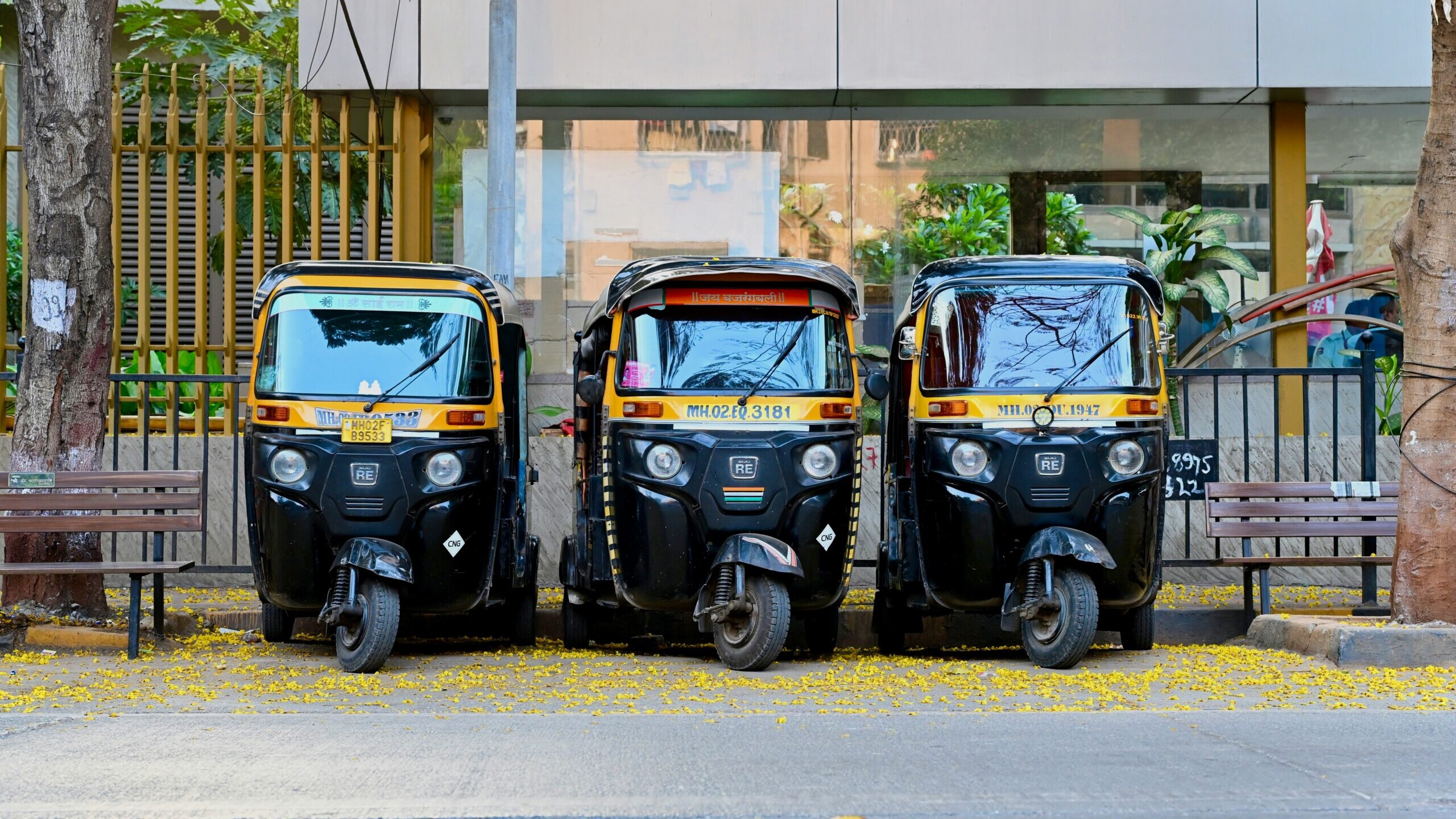 Authentic Indian auto rickshaw parked on a bustling street in India, surrounded by colorful storefronts and pedestrians