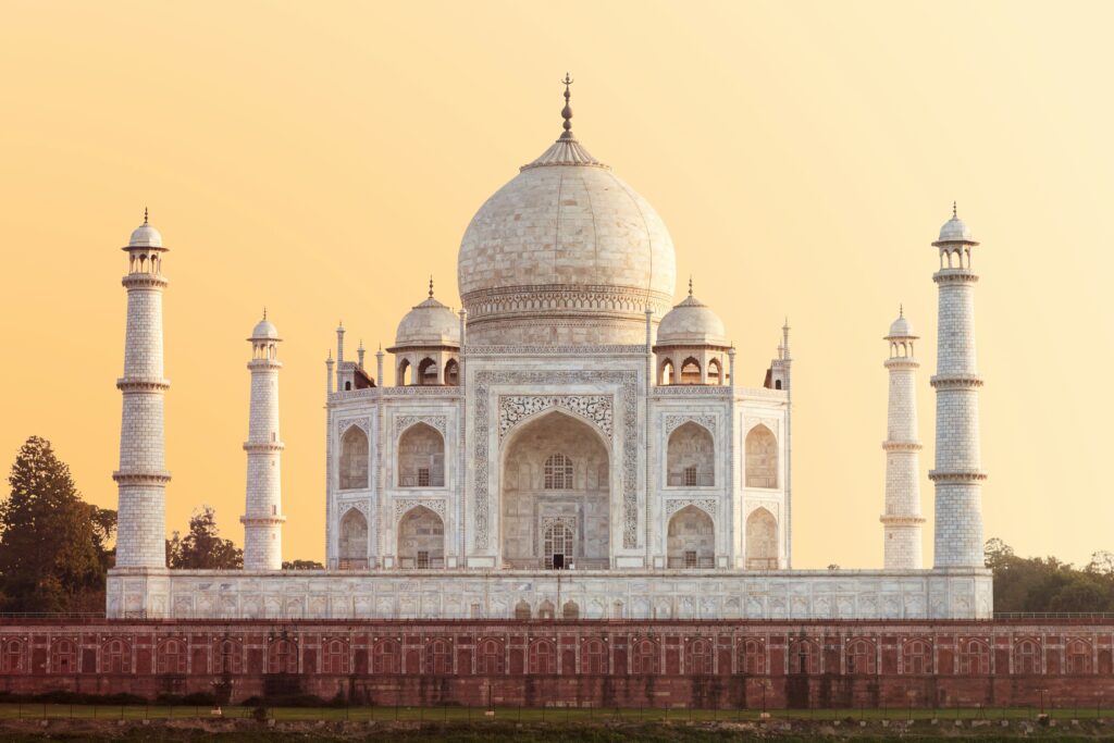 The Taj Mahal illuminated by the morning sun with reflective pools in front