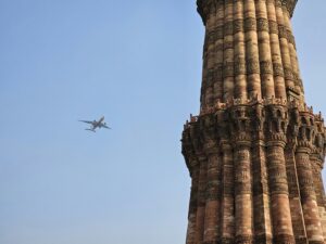 Airplane flying over the Qutub Minar in Delhi, India