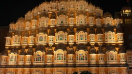 Close-up view of the Hawa Mahal, a pink sandstone palace with intricate lattice windows in Jaipur, India, under a soft sky