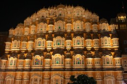 Close-up view of the Hawa Mahal, a pink sandstone palace with intricate lattice windows in Jaipur, India, under a soft sky