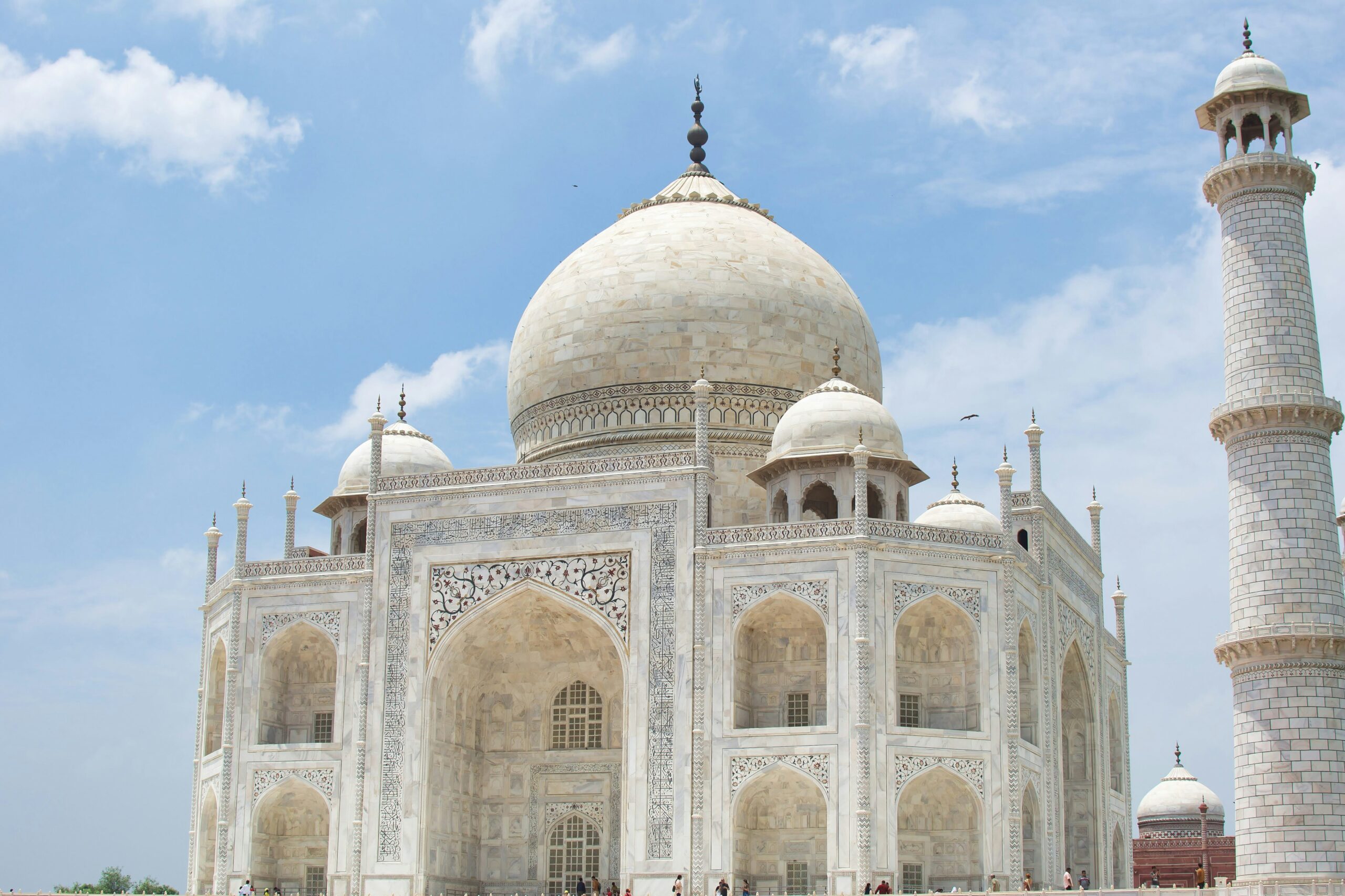 view of the Taj Mahal under a clear blue sky, showcasing its iconic white marble architecture in Agra, India,