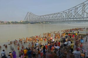 Saffron-clad sadhus taking a holy dip in the river at sunset