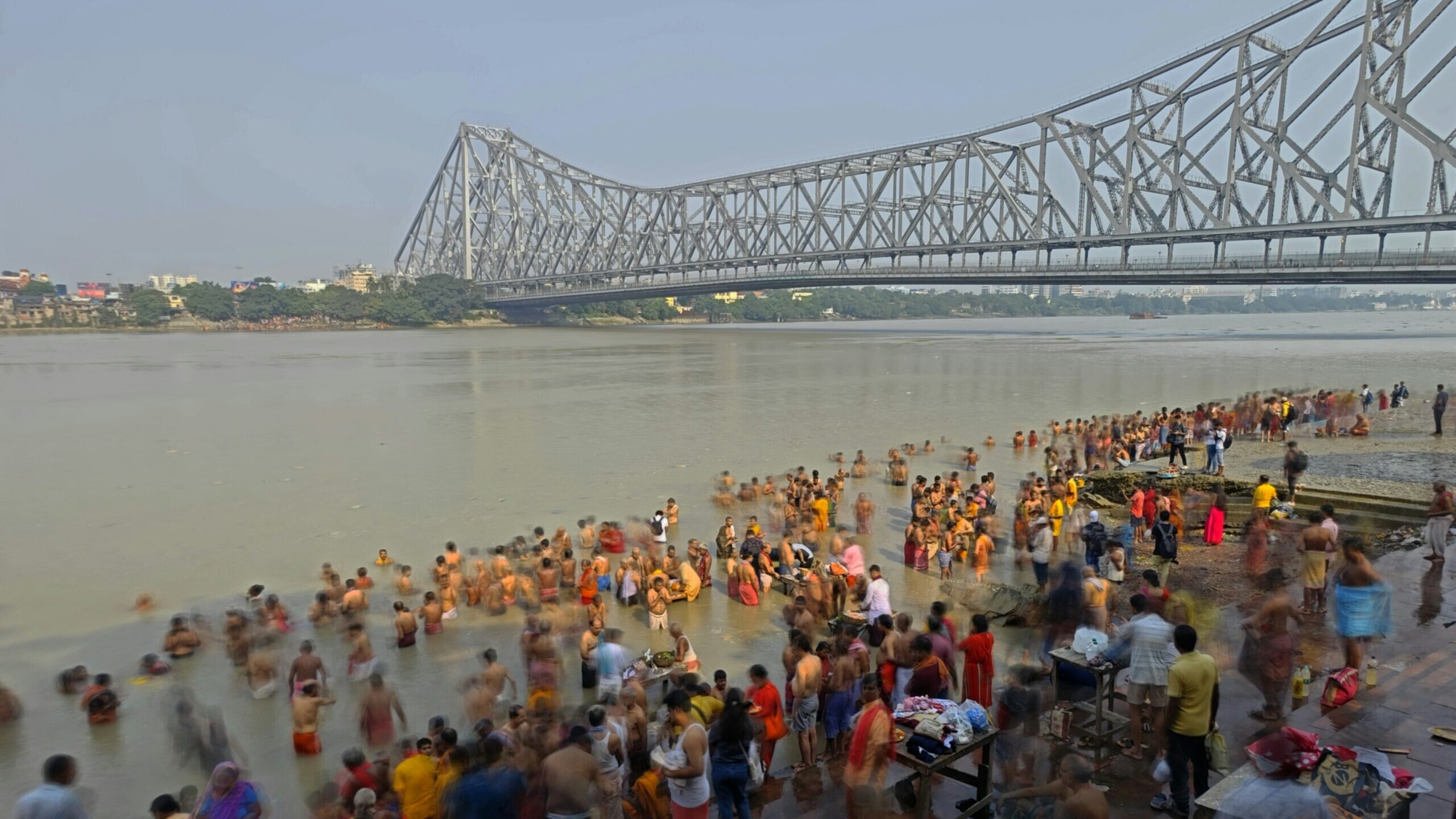 Saffron-clad sadhus taking a holy dip in the river at sunset