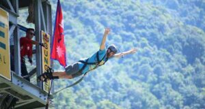 Person bungee jumping from a tall platform over the Ganges River in Rishikesh, India