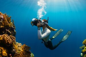 Scuba diver exploring colorful coral reefs and fish underwater in the Andaman Islands