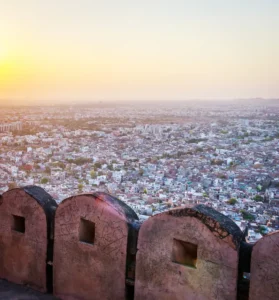 Question mark inside a white rectangle frame overlaid on a scenic view of Nahargarh Fort’s walls and ramparts at sunse